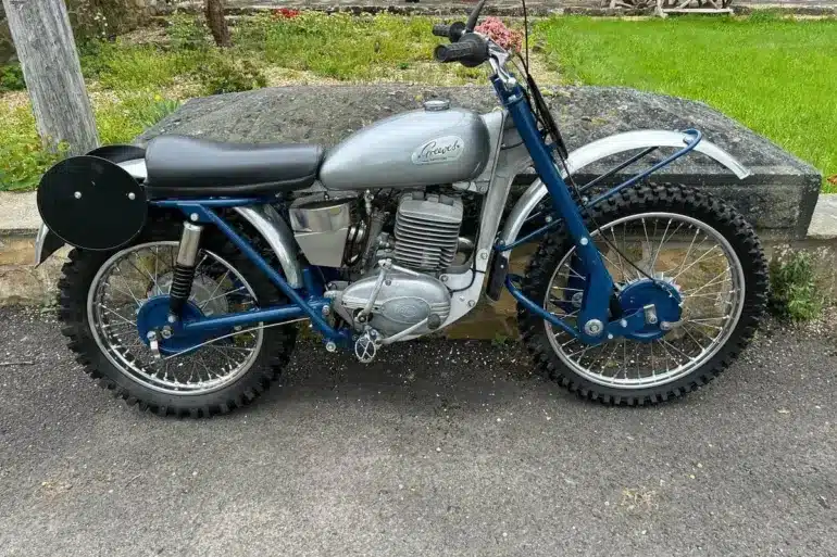 Seitenansicht einer blauen Greeves Hawkstone MCS 250cc von 1960, klassisches britisches Offroad-Motorrad mit periodentypischen Details.
