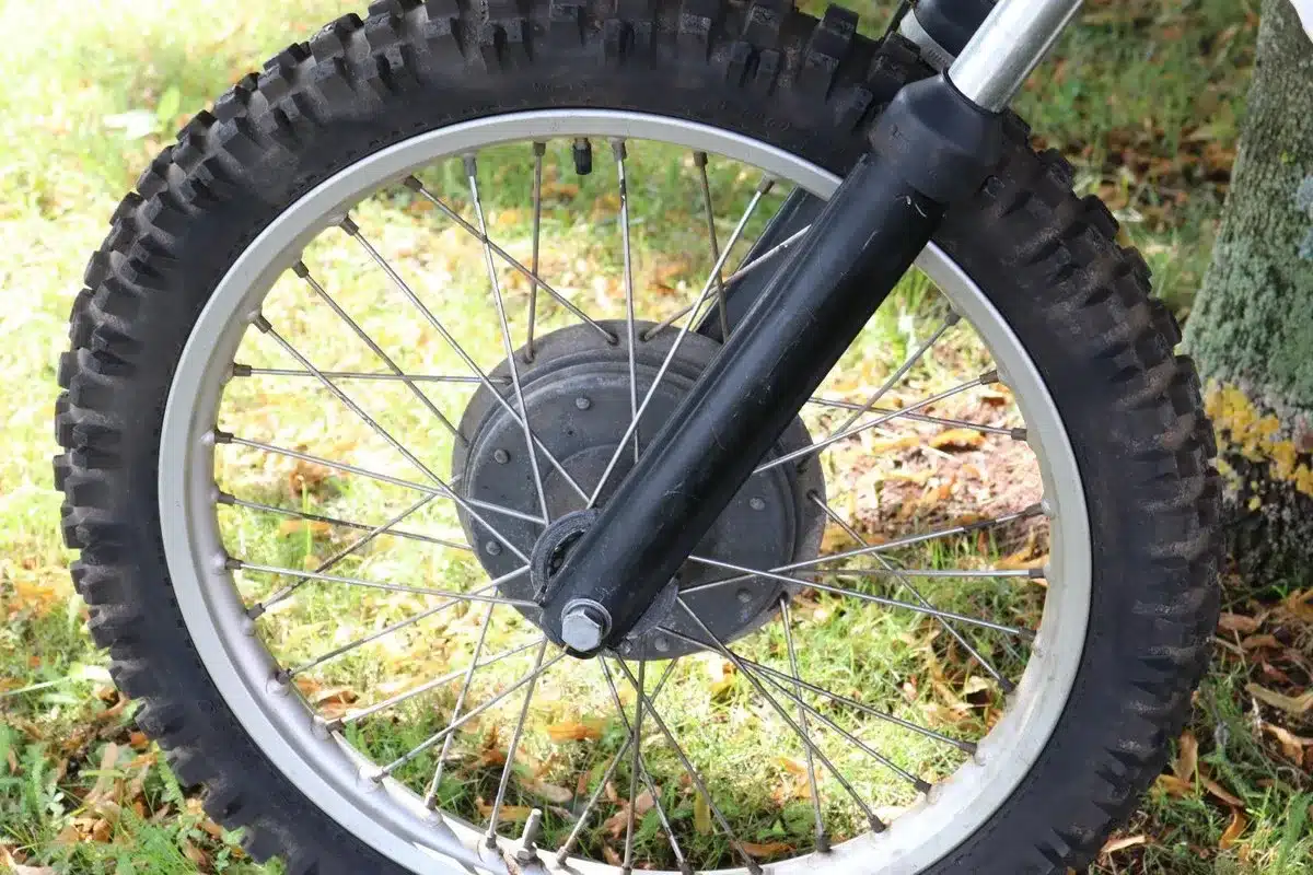 Nahaufnahme des Vorderrads einer Husqvarna 250 Cross von 1967 mit Stollenreifen und Trommelbremse.