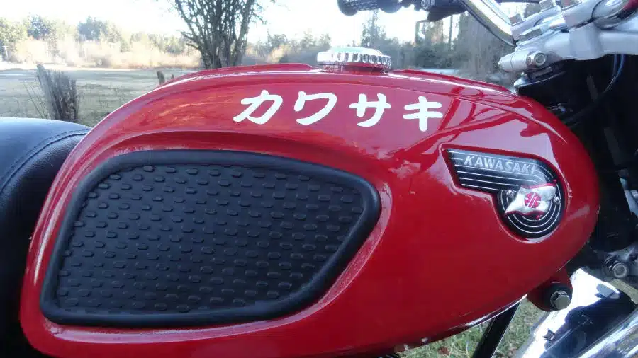 Nahaufnahme des Kraftstofftanks einer 1967er Kawasaki F2 175 mit Kawasaki-Schriftzug und japanischen Zeichen