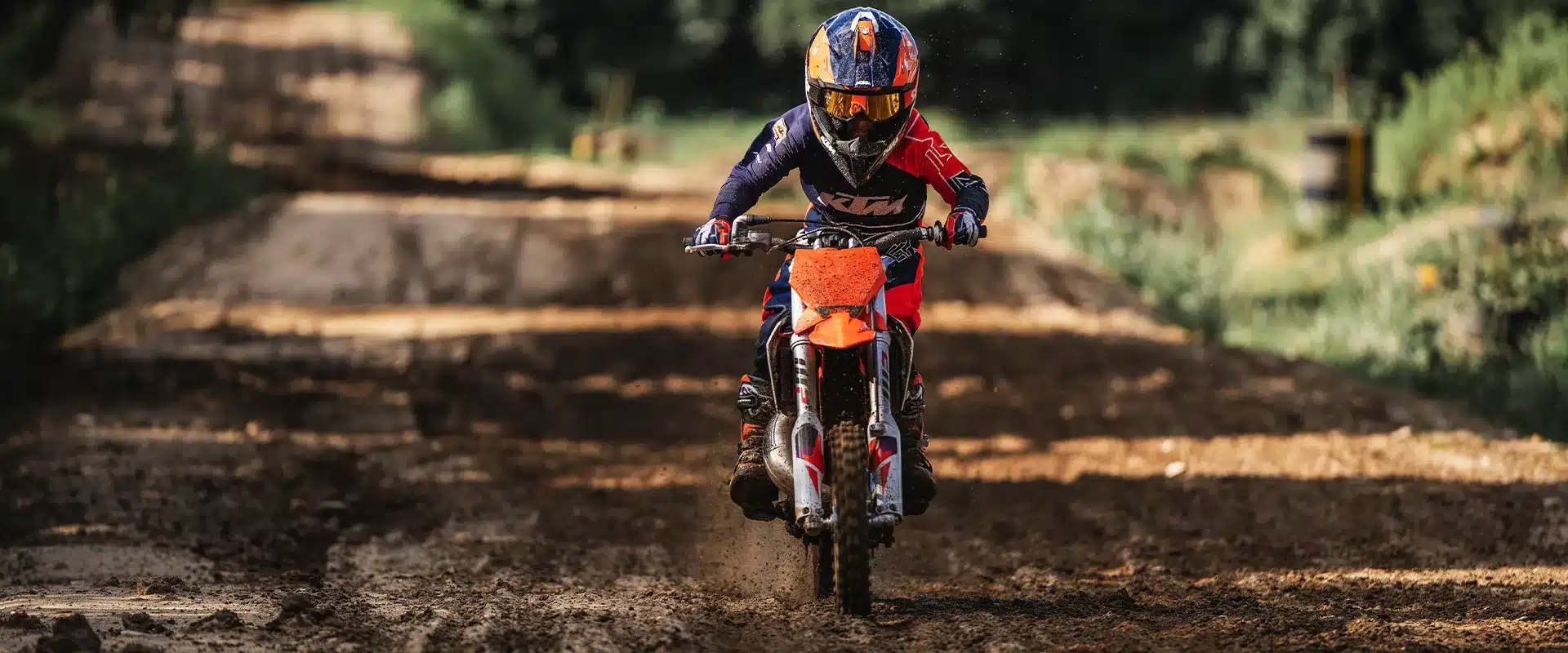 Junger Fahrer mit KTM 50 SX 2026 fährt Motocross auf einer Offroad-Strecke