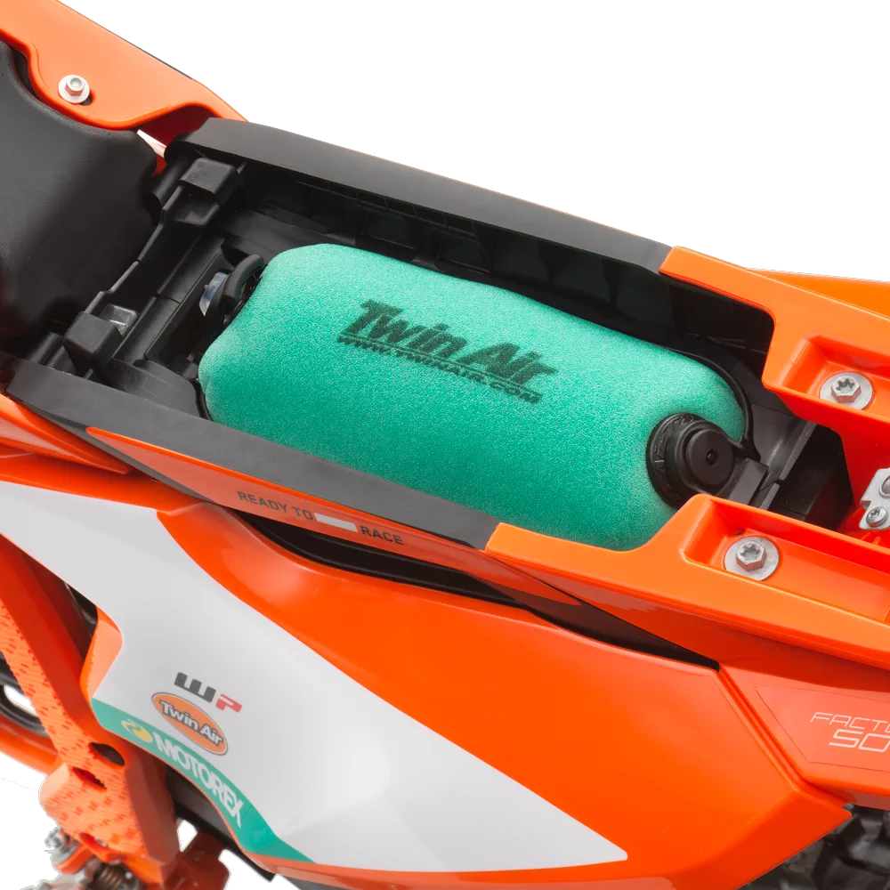 Luftfilter im Motorgehäuse der KTM 50 SX FACTORY EDITION 2026, eingebauter Twin Air Filter in orange-schwarzer Verkleidung
