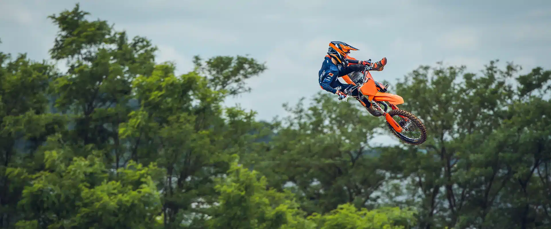 KTM 85 SX 19/16 Motocross-Motorrad beim Sprung über eine Strecke, Fahrer in voller Ausrüstung.