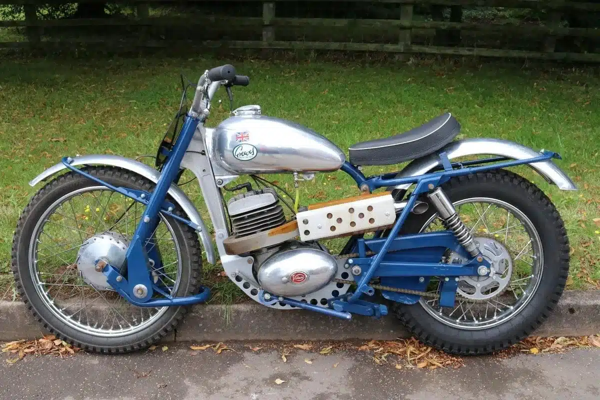 Vintage-Motorrad mit silber und blau, stehend am Straßenrand auf Grünfläche