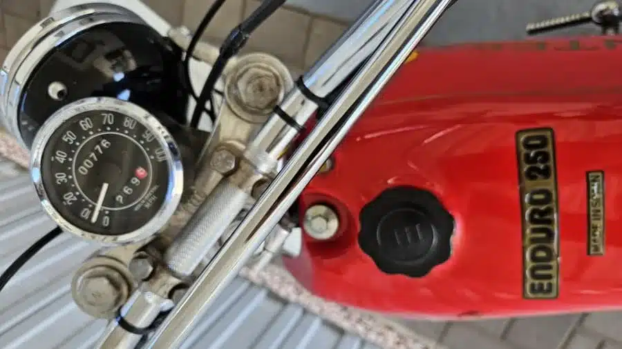 Nahaufnahme des Tachometers und des roten Tanks der Montesa Enduro 250 von 1975.