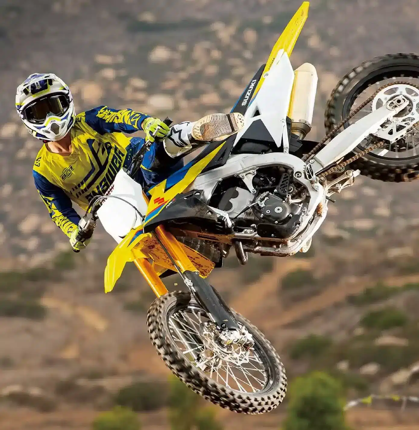 Motocross-Fahrer springt mit der Suzuki RM-Z250 auf einer staubigen Strecke.