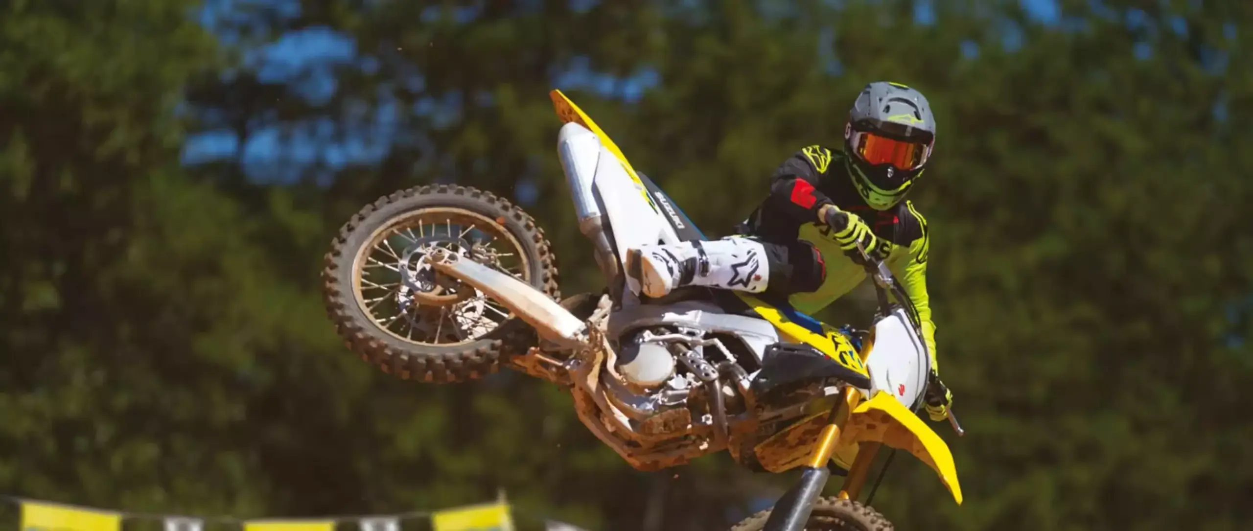 Motocross-Fahrer mit Suzuki RM-Z250 bei Sprung auf Offroad-Strecke