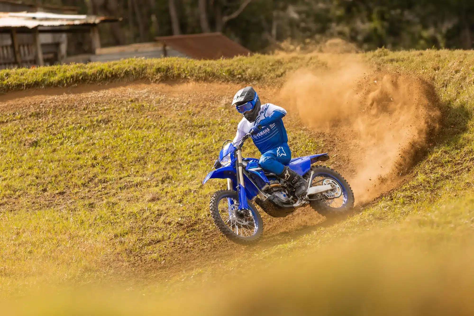 Yamaha WR450F wird von einem Fahrer in blauer Ausrüstung auf einer Geländestrecke dynamisch bewegt.