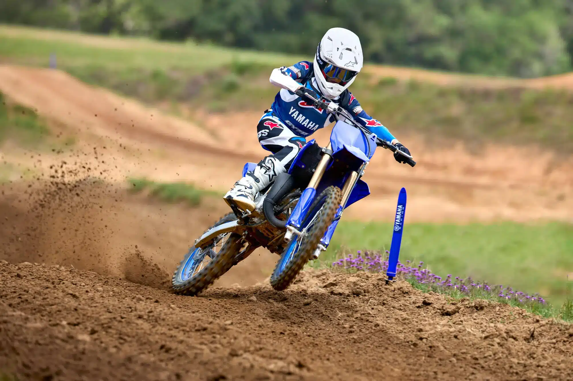 Yamaha YZ250 Motocross-Motorrad in Aktion auf einer Cross-Strecke, Fahrer in voller Schutzkleidung