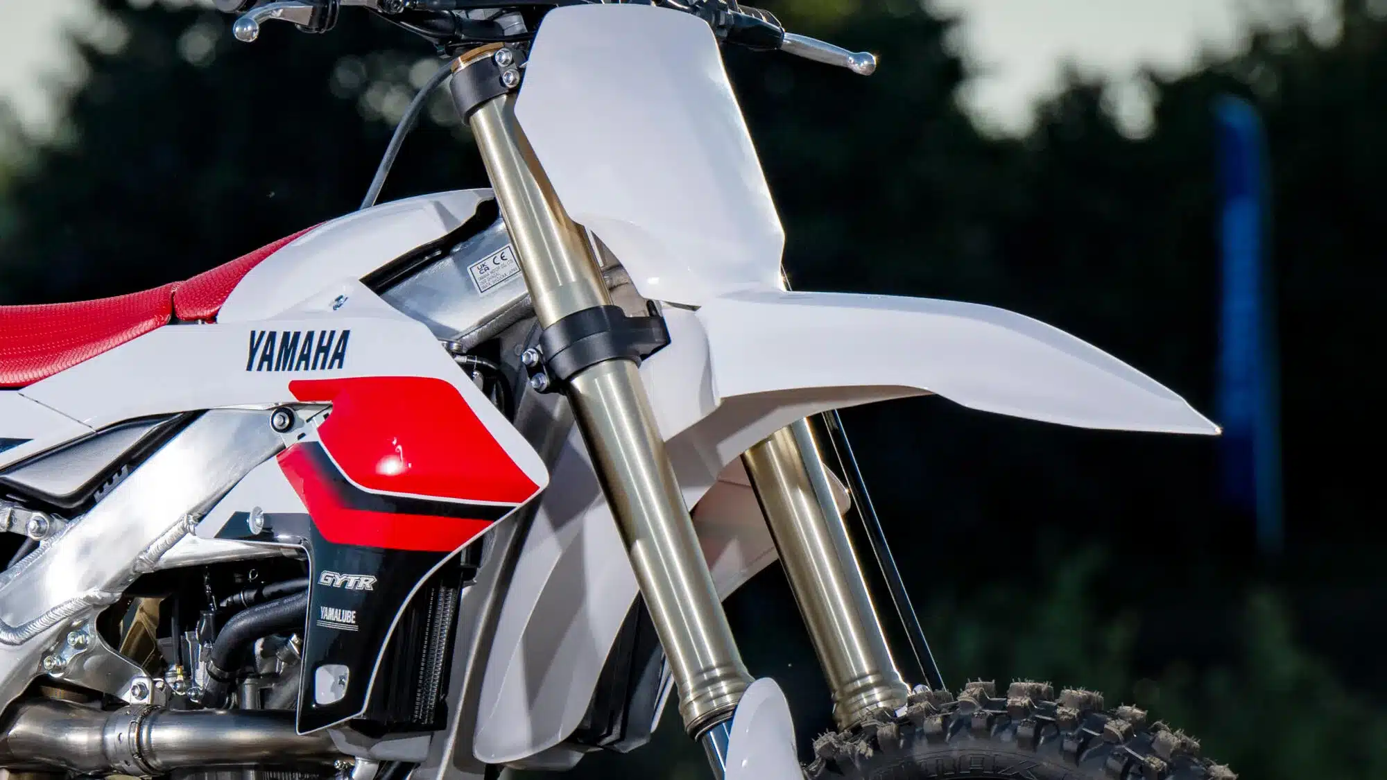 Nahaufnahme der Yamaha YZ250F 70th Anniversary Edition mit 70th-Grafik, rotem Sitz und Aluminiumrahmen.