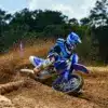 Motocross-Fahrer auf Yamaha YZ250F Monster Energy Edition beim Kurvenslide auf Sandstrecke.