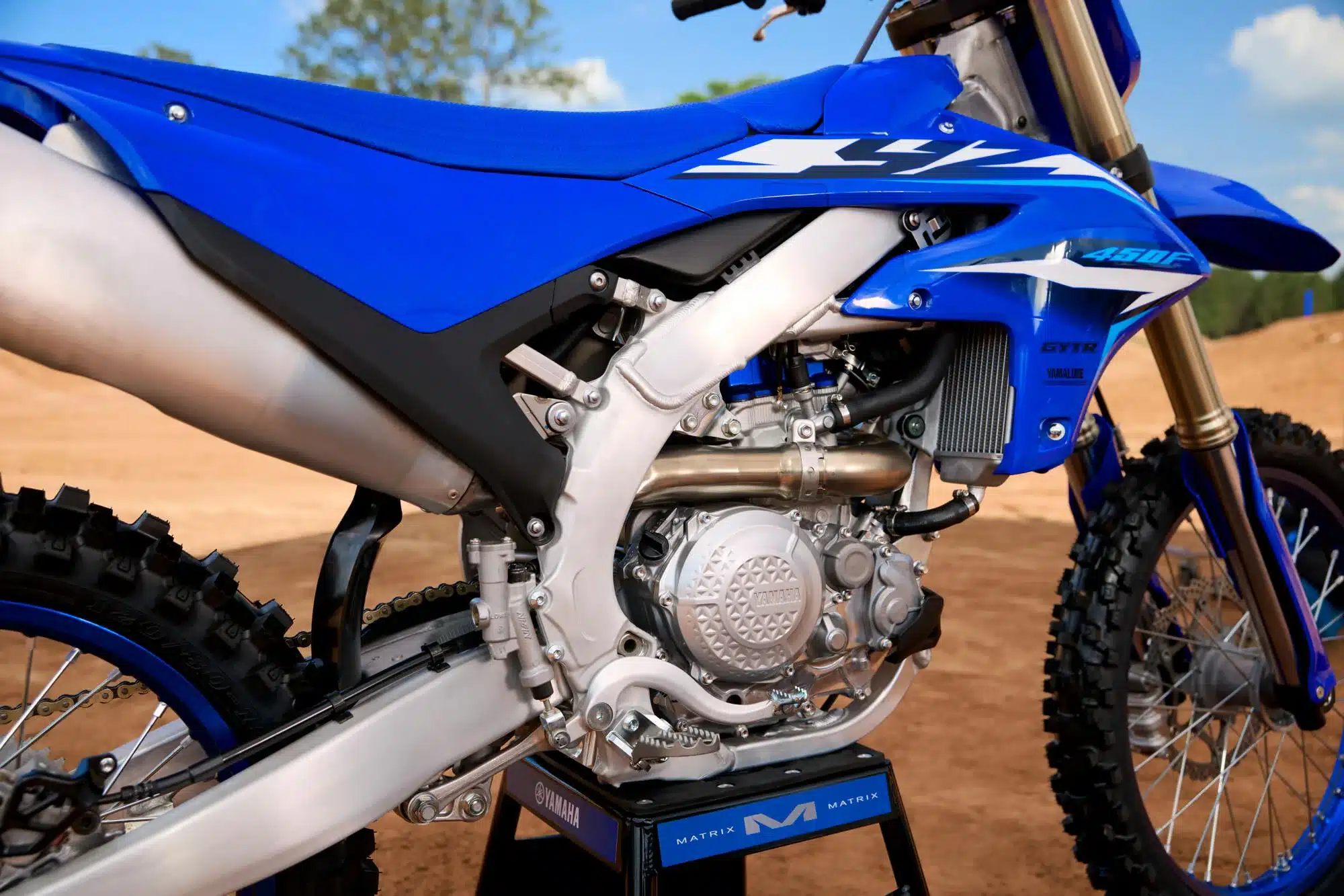 Nahaufnahme des Motors und Mittelbereichs der Yamaha YZ450F 2026 auf sandigem Untergrund