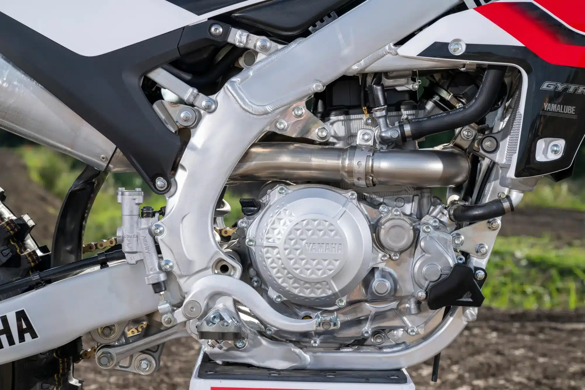 Detailaufnahme des Motors der Yamaha YZ450F 70th Anniversary Edition mit Aluminiumrahmen und Komponenten.