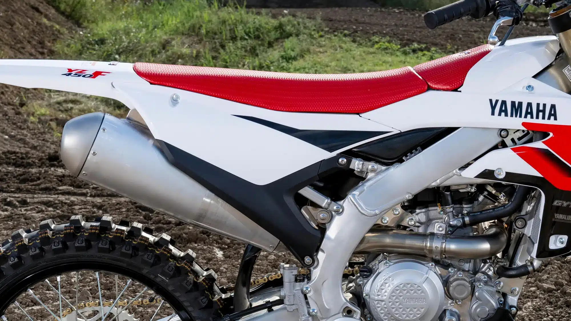 Yamaha YZ450F 70th Anniversary Edition mit roter Sitzbank, Aluminiumrahmen und Auspuff im Gelände