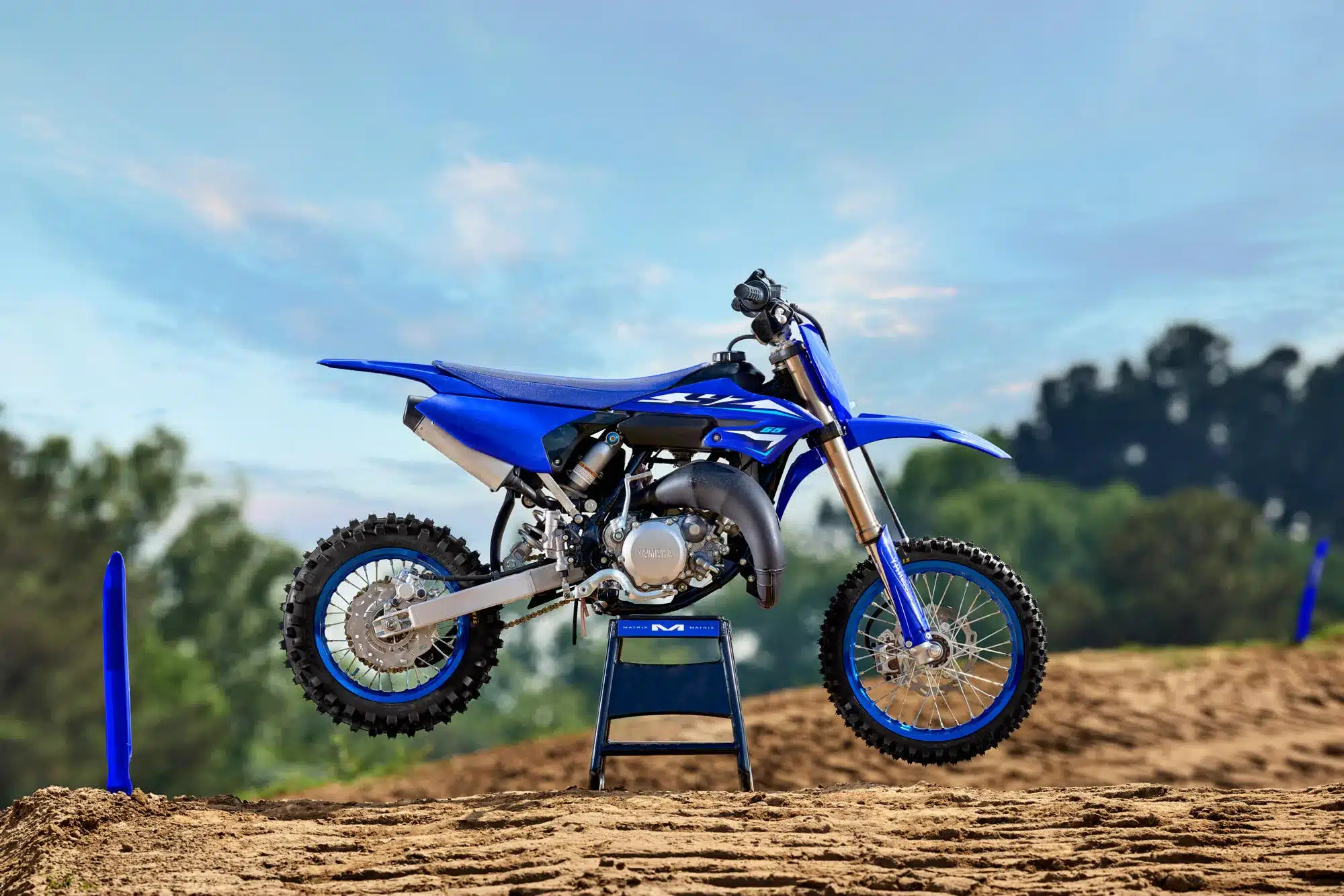 Yamaha YZ65 Kinder-Motocross-Motorrad auf einer Sandstrecke, Seitenansicht.