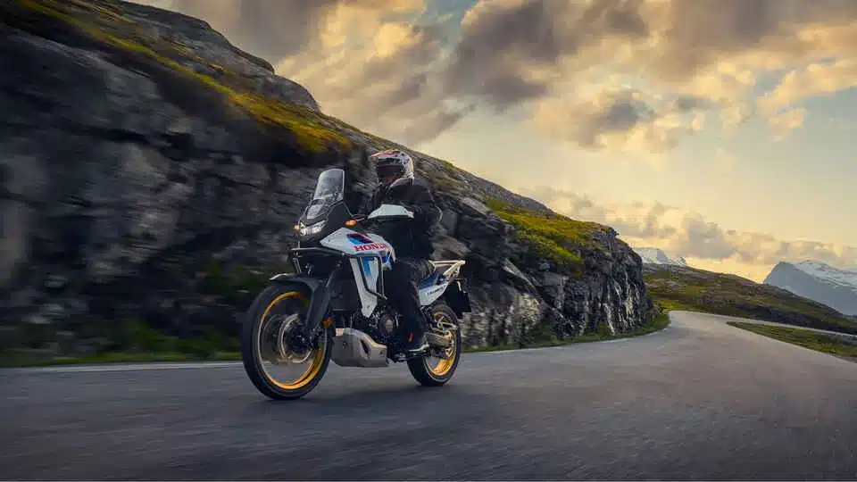 Honda XL750 Transalp fährt auf einer kurvigen Bergstraße bei Sonnenuntergang