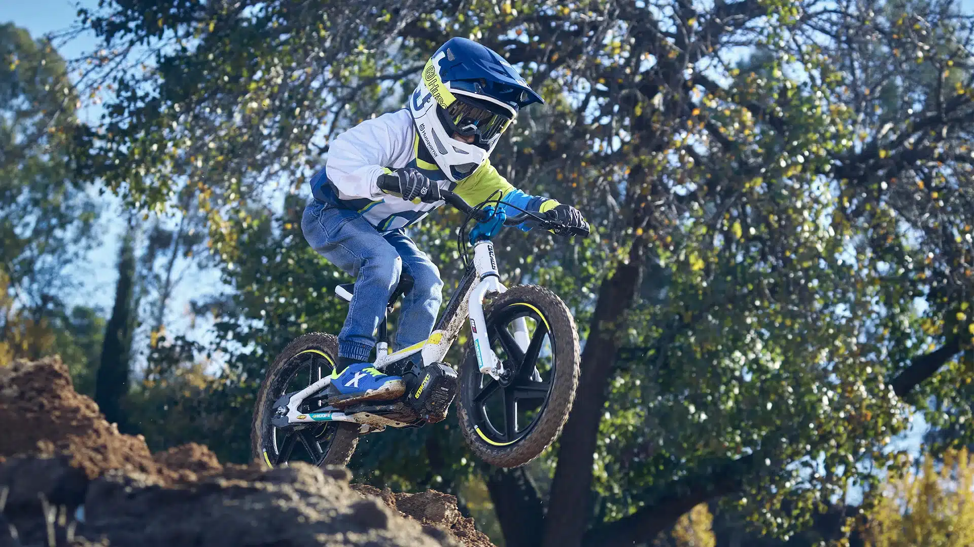 Kind fährt auf einer Husqvarna EE 1.16 Balance-Bike über einen Hügel im Offroad-Gelände