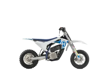 Seitenansicht der Husqvarna EE 3 2024, einem elektrischen Motocross-Motorrad für Kinder mit sportlichem Offroad-Design.