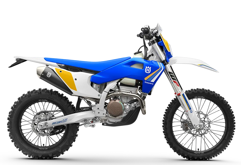 Seitenansicht der Husqvarna FE 350 Heritage 2025 mit charakteristischem blau-gelbem Design und Offroad-Bereifung.