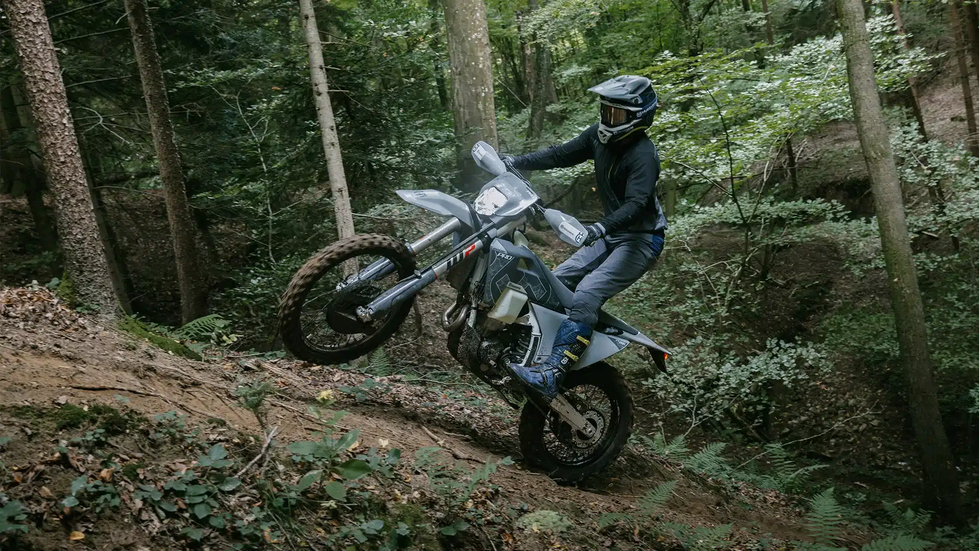Die Husqvarna FE 350 Pro 2026 wird in anspruchsvollem, steilem Waldgelände von einem Fahrer gefahren.