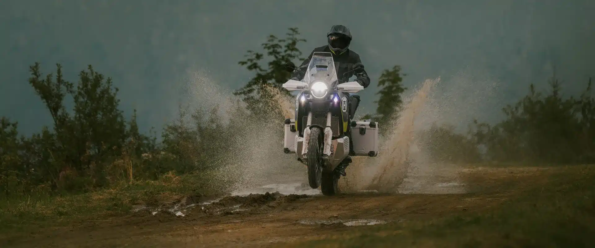 Adventure-Bike Husqvarna Norden 901 Expedition 2026 fährt mit Gepäck durch matschiges Gelände
