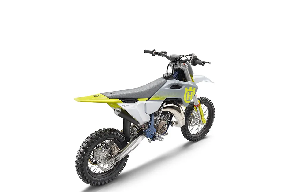 Motocross-Motorrad Husqvarna TC 65 2026 von hinten schräg fotografiert, steht auf weißem Hintergrund.
