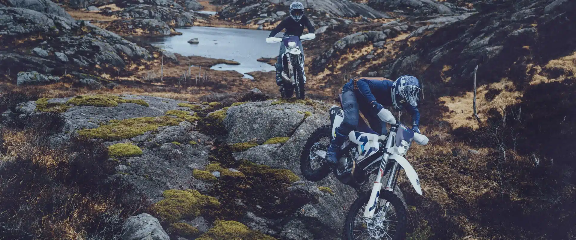 Zwei Enduro-Fahrer auf Husqvarna TE 300 2026 Motorrädern im felsigen Gelände