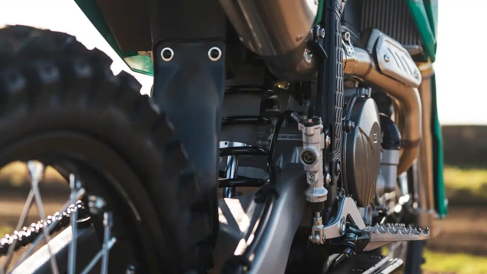 Nahaufnahme des Fahrwerks, Motors und Kettenantriebs der Kove MX450 Motocross-Maschine.