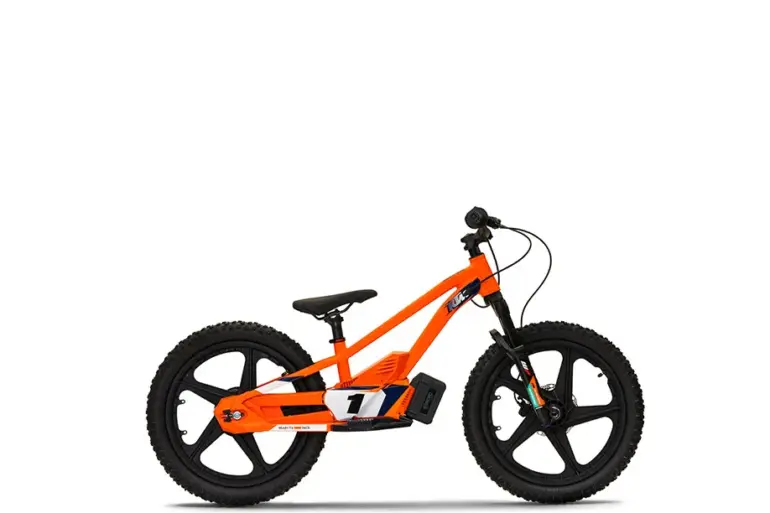Seitenansicht der KTM SX-E 1.20, ein orangefarbenes elektrisches Balance-Bike für Kinder mit schwarzen Details und KTM-Grafik
