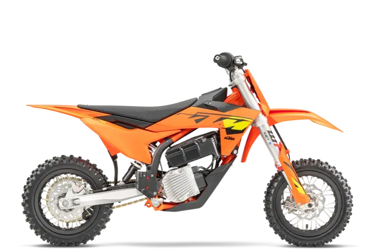 Seitenansicht einer KTM SX-E 3 2025, orangefarbenes elektrisches Kinder-Motocross-Motorrad auf weißem Hintergrund