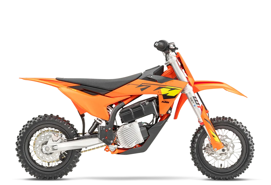 Seitenansicht einer KTM SX-E 3 2025, orangefarbenes elektrisches Kinder-Motocross-Motorrad auf weißem Hintergrund