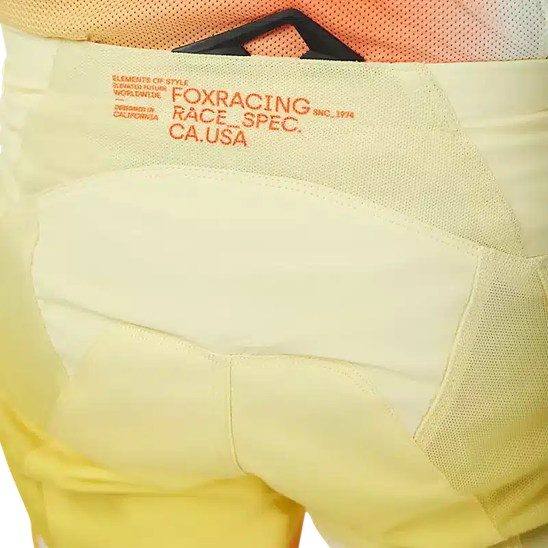 Detailfoto des oberen rückwärtigen Bereichs der gelben Fox Racing 180 Air Haze Motocross-Hose mit sichtbarer Logo-Bestickung.