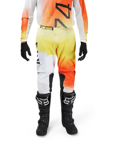 Motocrosshose Fox 180 Air Haze in Weiß-Gelb-Orange am Fahrer getragen, mit Knieeinsätzen aus Leder und Protektoren.