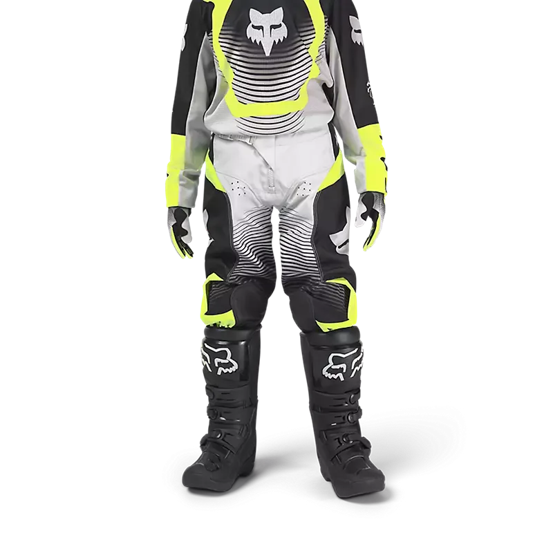 Jugendlicher in kompletter Fox Racing Motocross-Bekleidung, inklusive 180 Collect Hose in Grau, Schwarz und Gelb, stehend frontal fotografiert.