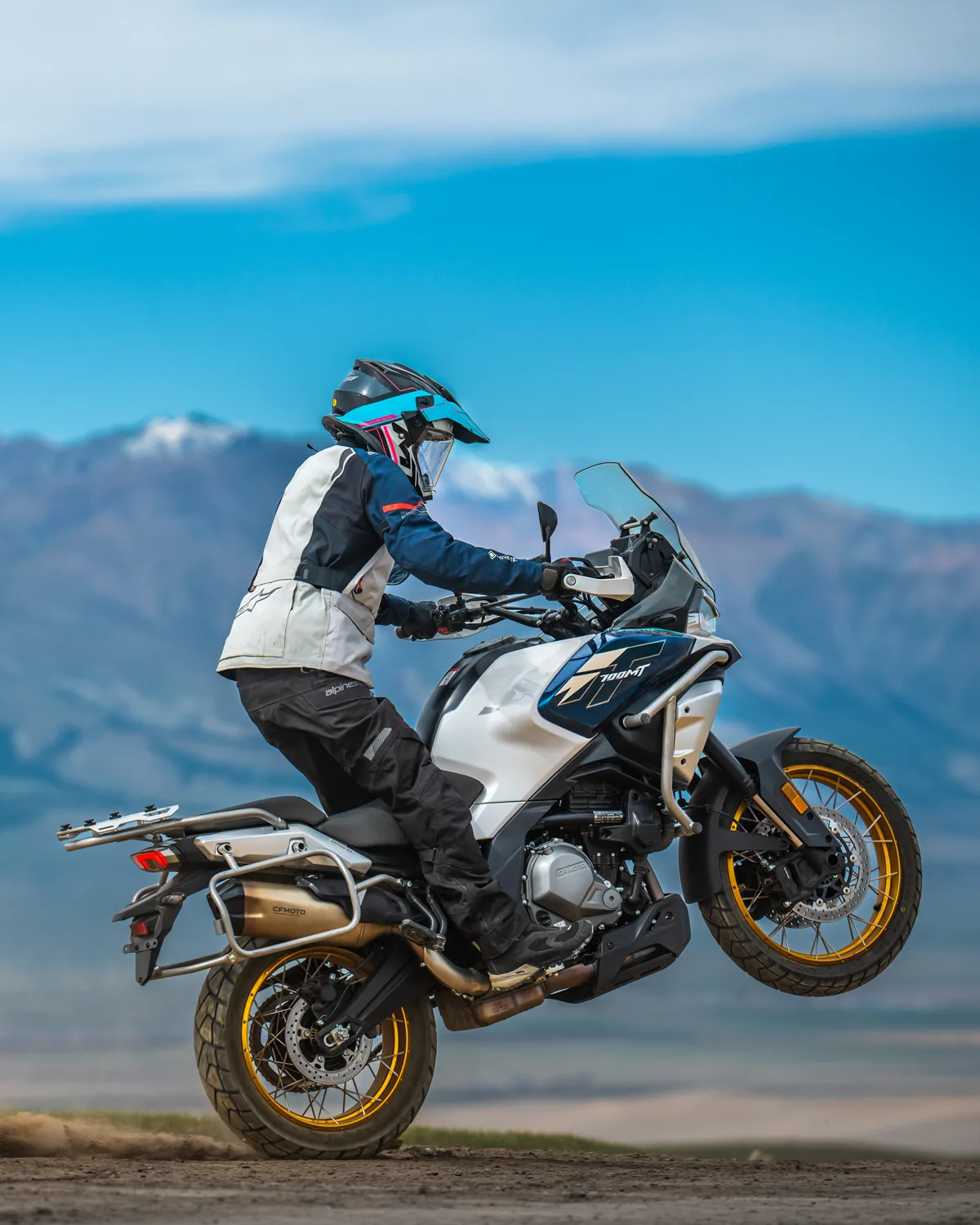 CFMOTO 700MT Adventure-Bike mit Fahrer auf Schotter vor Gebirgslandschaft