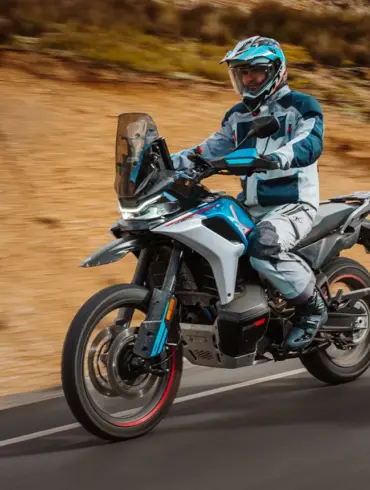 Adventure-Motorrad CFMoto 800MT-X auf Asphaltstraße mit Fahrer in voller Schutzkleidung