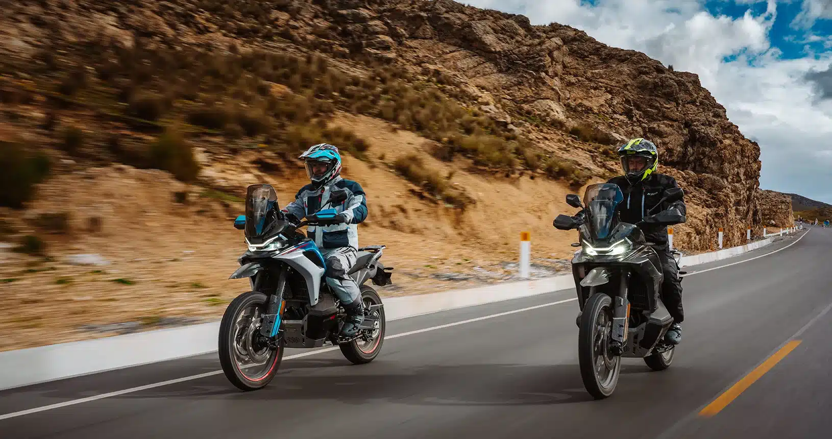 Zwei CFMoto 800MT-X Motorräder in Fahrt auf einer bergigen Landstraße