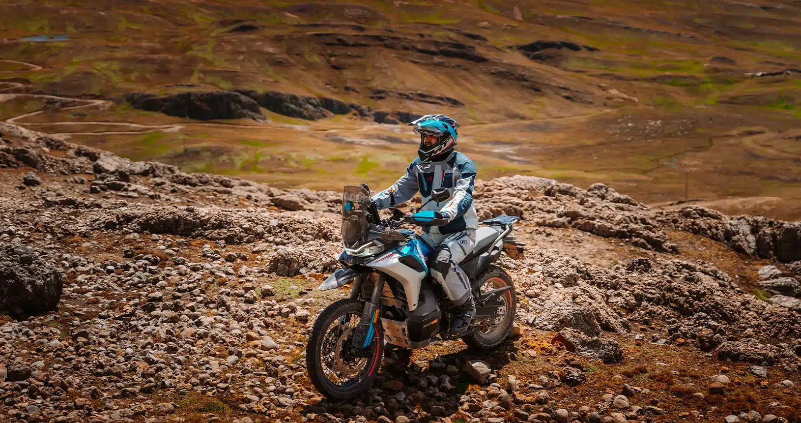 CFMoto 800MT-X Reiseenduro fährt im Gelände, mit Motorradfahrer in kompletter Schutzkleidung.