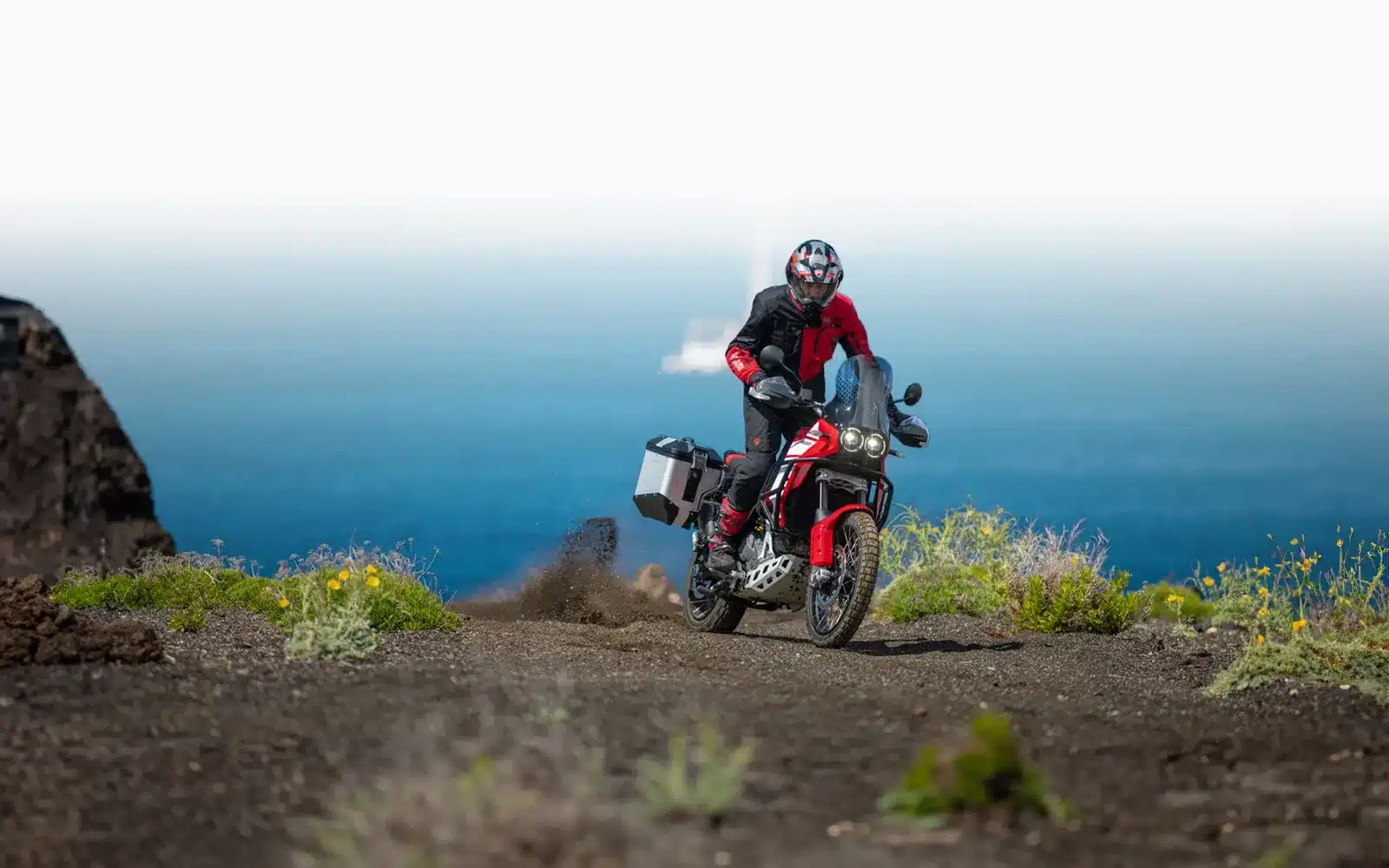 Abenteuerliche Fahrt mit der Ducati DesertX Discovery über unwegsames Gelände, Ausblick auf blauen Himmel.