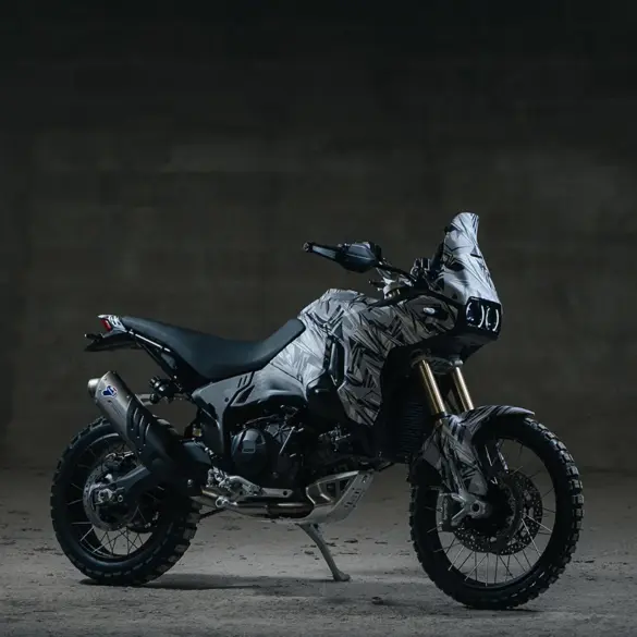 Seitenansicht einer Ducati DesertX V2 Reise-Enduro im Studio mit fokussiertem Offroad-Design und grobstolligen Reifen.