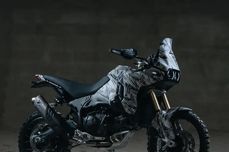 Seitenansicht einer Ducati DesertX V2 Reise-Enduro im Studio mit fokussiertem Offroad-Design und grobstolligen Reifen.