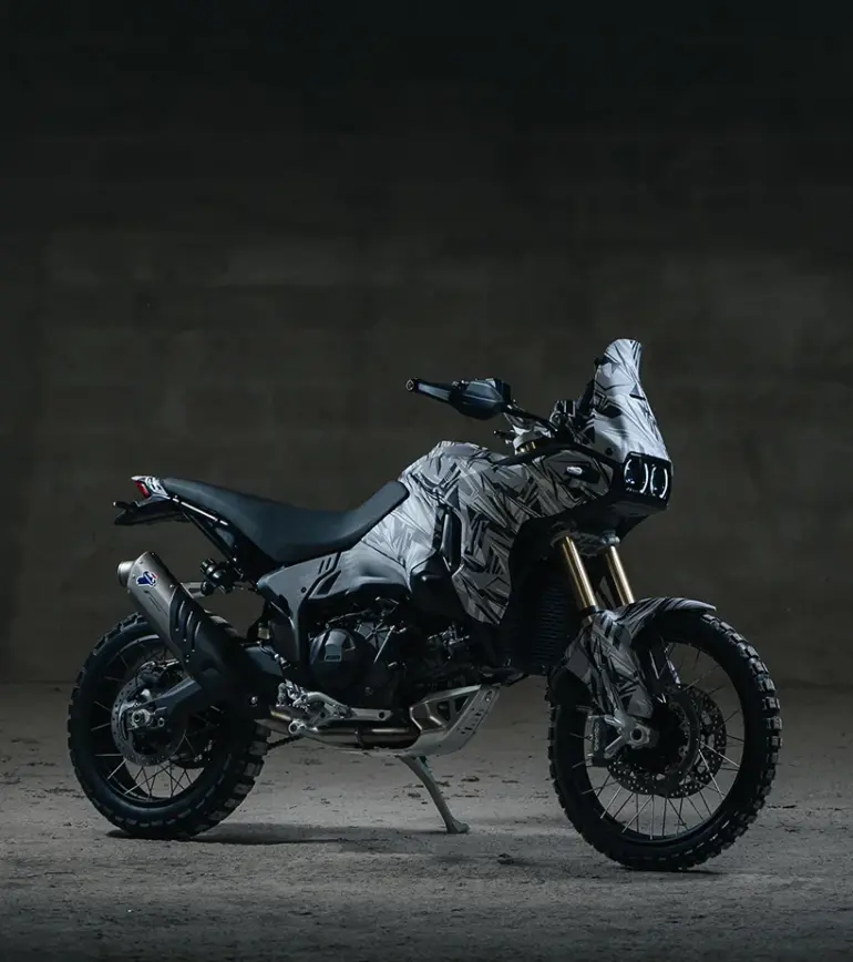 Seitenansicht einer Ducati DesertX V2 Reise-Enduro im Studio mit fokussiertem Offroad-Design und grobstolligen Reifen.