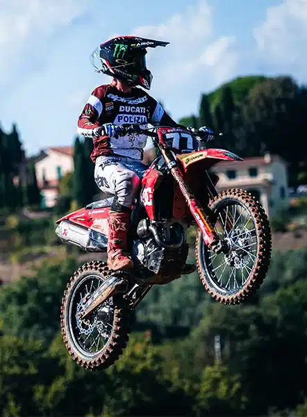 Motocross-Fahrer springt mit einer Ducati Desmo250 MX über eine Geländestrecke