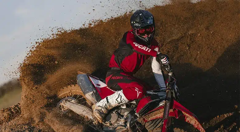 Motocross-Fahrer auf Ducati Desmo450 MX Factory bei schneller Kurvenfahrt auf losem Untergrund