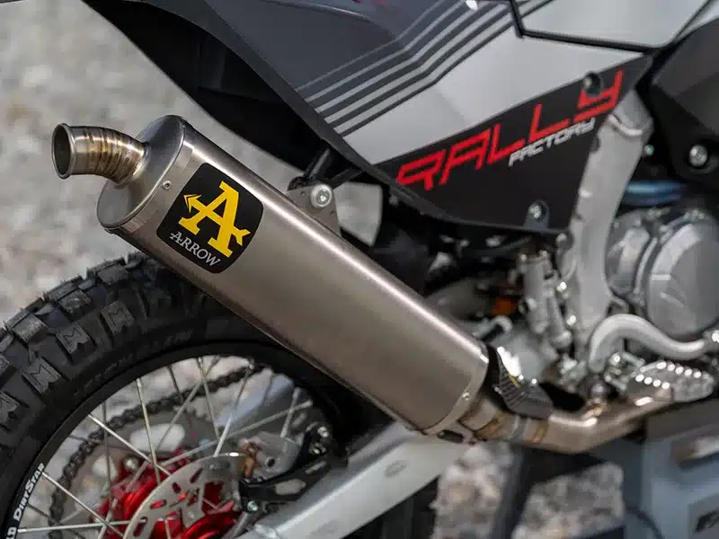 Nahaufnahme eines Arrow Titan-Auspuffs an einer Fantic XEF Rally Factory mit grobstolligem Hinterreifen