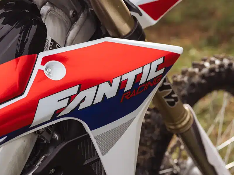Nahaufnahme der Seitenverkleidung der Fantic XXF 250 2026 mit Fantic Racing Logo und Aluminiumbauteilen
