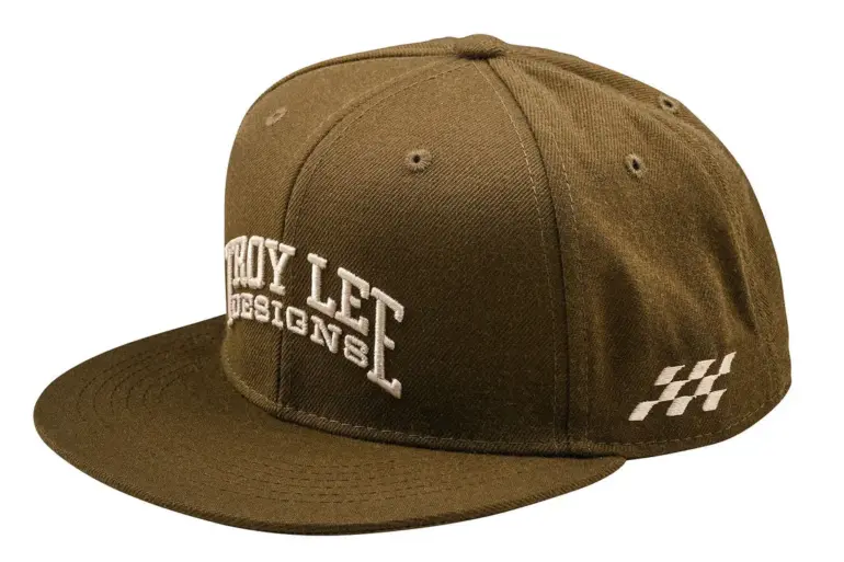Olivefarbene Snapback Cap Flat Bill Scholar von Troy Lee Designs mit flachem Schirm und weißer Stickerei.