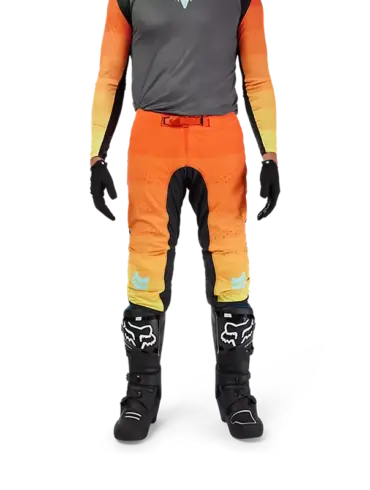 Flexair Grid Hose in Schwarz/Orange, getragen von einer Person mit Motocross-Stiefeln und Handschuhen, Vorderansicht.