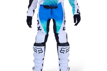 Jugendliche Motocross-Fahrerin trägt die blaue Fox Flexair Spire Hose mit Schutzstiefeln auf weißem Hintergrund