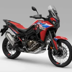 Honda CRF1100L Africa Twin 2024 Motorrad in Rot, Seitenansicht, im Studio vor grauem Hintergrund.