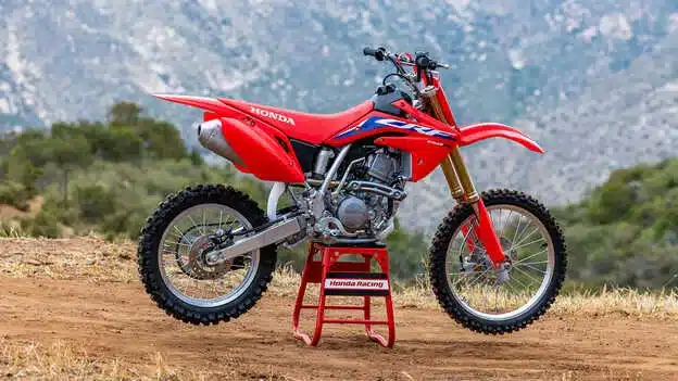 Seitenansicht einer roten Honda CRF150R Motocross-Maschine auf einem Ständer im Freien